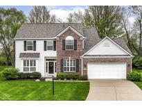 Charming two-story home featuring a brick and white siding facade and a well-manicured front yard at 10524 Hawks Ridge Ct, Fishers, IN 46037
