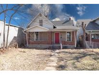 Charming two-story home with red door and covered porch, showcasing classic architectural details at 1425 S Belmont Ave, Indianapolis, IN 46221