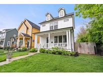 Charming white two-story home boasts a welcoming front porch and manicured lawn at 2044 Alvord St, Indianapolis, IN 46202