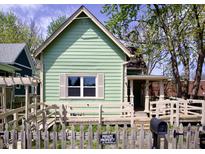 Charming, light green home with a well-maintained yard, quaint fence and accessible ramp at 474 N Randolph St, Indianapolis, IN 46201