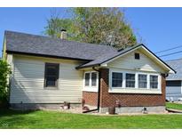 Charming home with tan siding, brick foundation, and a well-maintained lawn at 480 E Walnut St, Martinsville, IN 46151