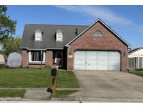 Charming brick home featuring a well-maintained lawn, attached garage, and inviting curb appeal at 623 White Ash Trl, Mooresville, IN 46158