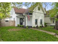 Charming exterior view of a well-kept two-story home with an American flag and manicured lawn at 629 N Keystone Ave, Indianapolis, IN 46201