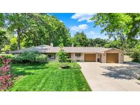 Charming ranch home featuring a manicured lawn, mature trees, and a two-car garage at 6440 Saint Joe Dr, Indianapolis, IN 46217