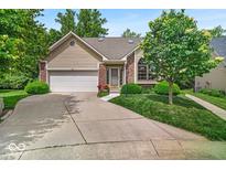 Charming single-story home with a well-manicured lawn, complemented by a two-car garage and mature trees at 65 Palomino Ct, Zionsville, IN 46077
