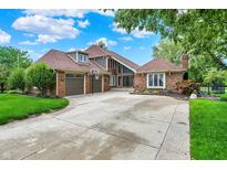 Expansive brick home with attached garage, a long driveway, and lush landscaping at 676 La Placita St, Greenwood, IN 46143