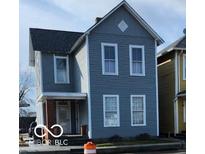Charming two-story home with gray siding and white trim, featuring a covered porch and a classic architectural design at 725 E New York E St, Indianapolis, IN 46202