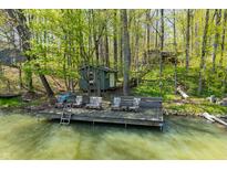 Inviting waterfront cabin features a spacious wooden dock with seating, perfect for enjoying serene lake views and outdoor relaxation at 8277 N Lasalle Rd, Morgantown, IN 46160