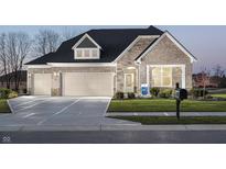 Charming stone and brick home featuring a three-car garage and well-manicured lawn at 8436 Paxton Dr, Brownsburg, IN 46112