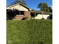 Charming single-story home with a well-maintained lawn and attached two car garage at 1205 N Gibson Ave, Indianapolis, IN 46219