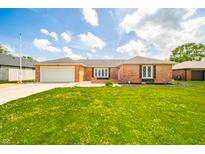 Charming brick home with a well-manicured lawn and attached garage, perfect for suburban living at 1823 E 44Th St, Anderson, IN 46013