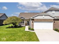 Charming home featuring brick accents, a well-manicured lawn, and an attached two car garage with a wide driveway at 2342 Sheek Rd, Greenwood, IN 46143