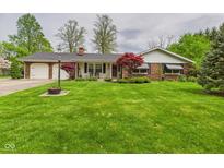 Charming ranch-style home featuring a brick exterior, well-manicured lawn, and mature trees at 3824 Oakwood Blvd, Anderson, IN 46011