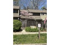 Charming townhome featuring flowering trees and a well-maintained wooden fence for added privacy at 4212 Foxglove Trce, Indianapolis, IN 46237