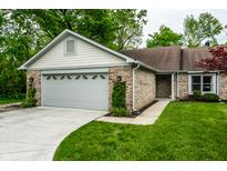 Charming single-story home features brick facade, attached garage, and a well-maintained front yard with mature trees at 5204 Whipple Wood Ct, Indianapolis, IN 46226