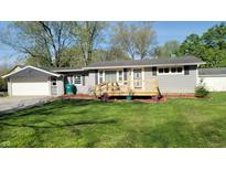 Charming single-story home with a wooden front porch and manicured lawn at 5831 Aho Dr, Avon, IN 46123