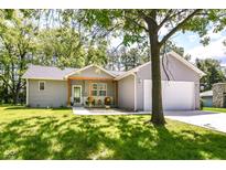 Charming single-story home with gray siding, a covered porch, and a well-manicured lawn at 6301 Prospect St, Indianapolis, IN 46203