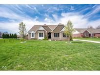 Charming brick home with a well-manicured lawn and beautiful landscaping at 6784 W May Apple Dr, McCordsville, IN 46055