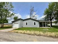 Charming gray home featuring a front-facing garage and lush green lawn and yard at 692 S Crawford St, Martinsville, IN 46151