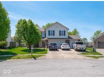 Charming two-story home with a well-manicured lawn, driveway, and beautiful landscaping at 7611 Penguin Cir, Indianapolis, IN 46239