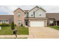 Inviting two-story home featuring a brick and gray siding exterior and an attached two-car garage at 7643 Belmac Ln, Camby, IN 46113