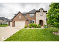 Stunning two-story brick home featuring a spacious front yard with a long driveway at 9949 Stable Stone Ter, Fishers, IN 46040