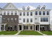 Modern townhomes with brick, stone, and siding exteriors and well-manicured lawns create an inviting curb appeal at 10959 Belgian Ln, Zionsville, IN 46077