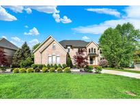 Brick home with a green lawn and landscaping at 13934 Salsbury Creek Dr, Carmel, IN 46032