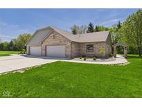 Well maintained brick house with a three car garage, manicured lawn, and covered walkway at 2327 Mimosa Ln, Anderson, IN 46011