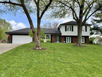 Charming two-story home with a well-manicured lawn and mature trees provides great curb appeal at 337 Leaning Tree Rd, Greenwood, IN 46142