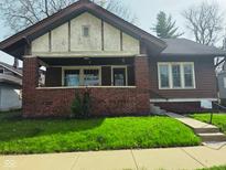 Charming craftsman-style home featuring a covered front porch and well-maintained lawn at 551 E 40Th St, Indianapolis, IN 46205