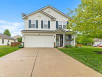 Charming two-story home with a well-manicured lawn and attached two-car garage at 5550 Sweet River Dr, Indianapolis, IN 46221