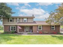 Charming two-story home with brick and vinyl siding, a well-manicured lawn, and an inviting covered porch at 5901 W Thompson Rd, Indianapolis, IN 46221