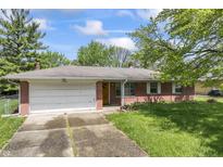 Charming single-story brick home with attached garage, well-maintained lawn, and classic architectural details at 7412 Hiner Ln, Indianapolis, IN 46219