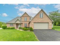 Inviting brick home with well-manicured lawn and attached two car garage at 801 Echo Trl, Martinsville, IN 46151