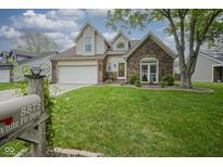 Charming two-story home with a brick facade, manicured lawn, and attached two-car garage at 8875 White Fir Dr, Indianapolis, IN 46256