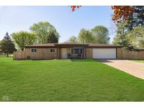 Charming ranch-style home featuring a spacious front yard, attached garage, and cozy front porch at 9748 W Sunset Ln, Elwood, IN 46036