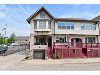 Charming two-story home featuring a covered porch, red deck, and attached garage at 114 E 27Th St, Indianapolis, IN 46205