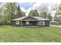 Charming single-story home featuring dark siding, light wood accents, and a well-maintained lawn at 1301 Stafford Rd, Plainfield, IN 46168
