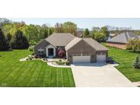 Beautiful brick home with an attached two-car garage and professionally landscaped front yard at 1426 Manchester Dr, Danville, IN 46122