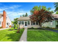 Charming single-story home featuring manicured lawn, mature landscaping, and inviting front porch at 2512 E 57Th St, Indianapolis, IN 46220