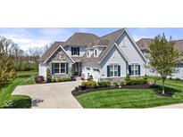 Charming home with stone accents, blue shutters, a well-manicured lawn, and an attached garage at 3678 Sugar Pine Ln, Zionsville, IN 46077
