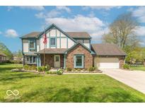 Charming two-story home with a brick facade, manicured lawn, and an American flag at 562 Covered Bridge Rd, Greenwood, IN 46142