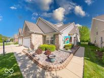 Charming townhome with a brick front, manicured lawn, and walkway to the front door at 6146 Franklin Villas Way, Indianapolis, IN 46237