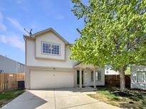 Charming two-story home with attached garage, landscaped front yard and beautiful mature tree on a sunny day at 6628 Dunsdin Dr, Plainfield, IN 46168