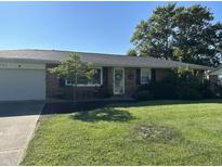 Charming brick ranch home featuring a lush front lawn and mature trees in a desirable neighborhood at 762 N Dellasburg Rd, Columbus, IN 47203