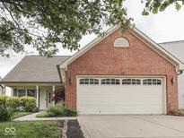 Charming single-story home featuring a red brick facade and a two-car garage with a well-manicured lawn at 820 Scotch Pine Dr, Greenwood, IN 46143