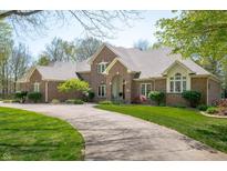 Charming brick home featuring a well-manicured lawn and a long driveway leading to the residence at 923 Woodcrest Way, Anderson, IN 46012