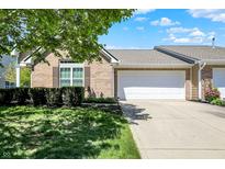 Charming brick home with a two-car garage, manicured lawn, and lush green landscaping on a sunny day at 10992 Chapel Woods S Blvd, Noblesville, IN 46060