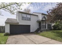 Two-story home featuring a two-car garage, manicured lawn, and cozy front porch at 110 Meadow Creek Blvd, Whiteland, IN 46184